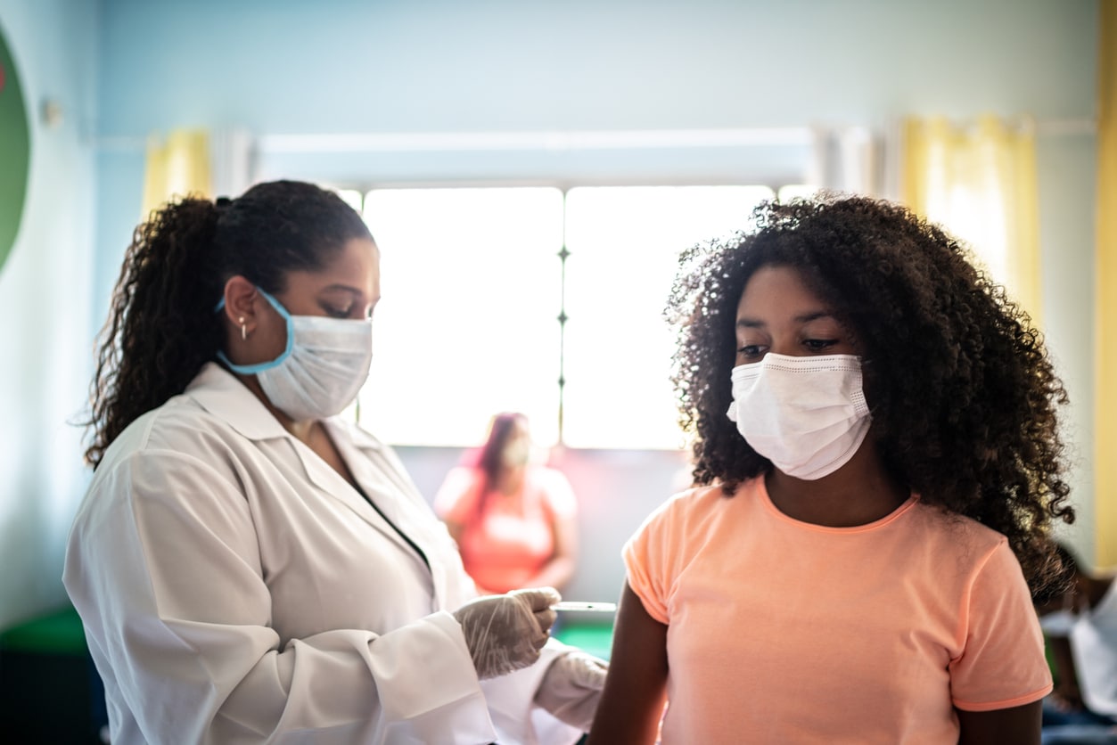 Une petite fille se fait vacciner dans sa classe