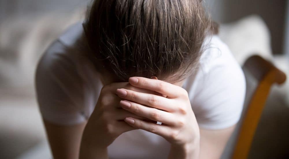 femme tête dans les mains, proposition de loi, violences contre les soignants