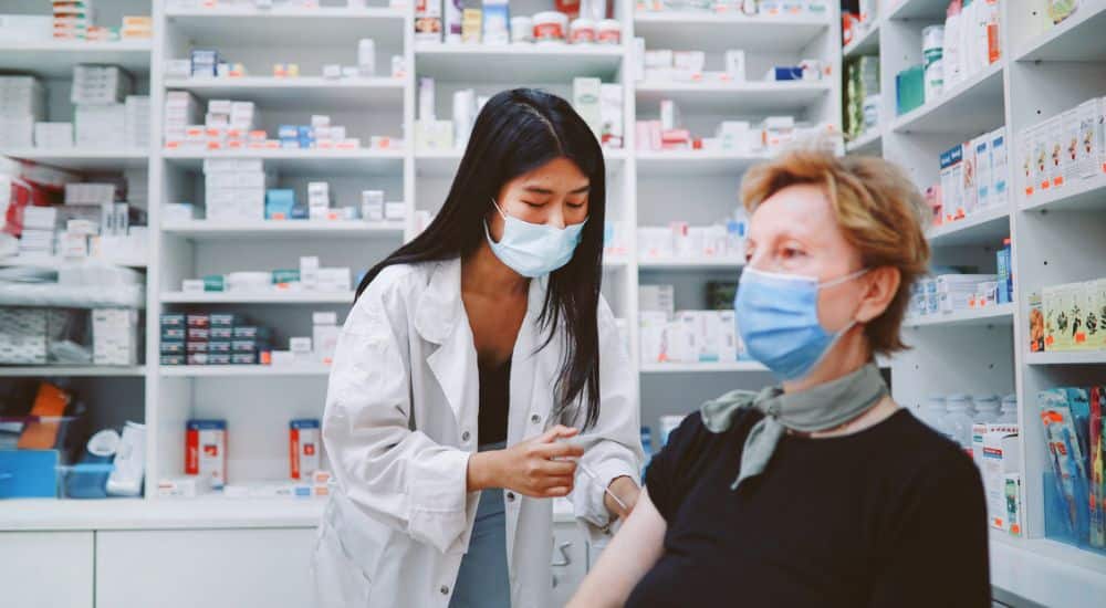 Pharmacienne vaccinant une patiente