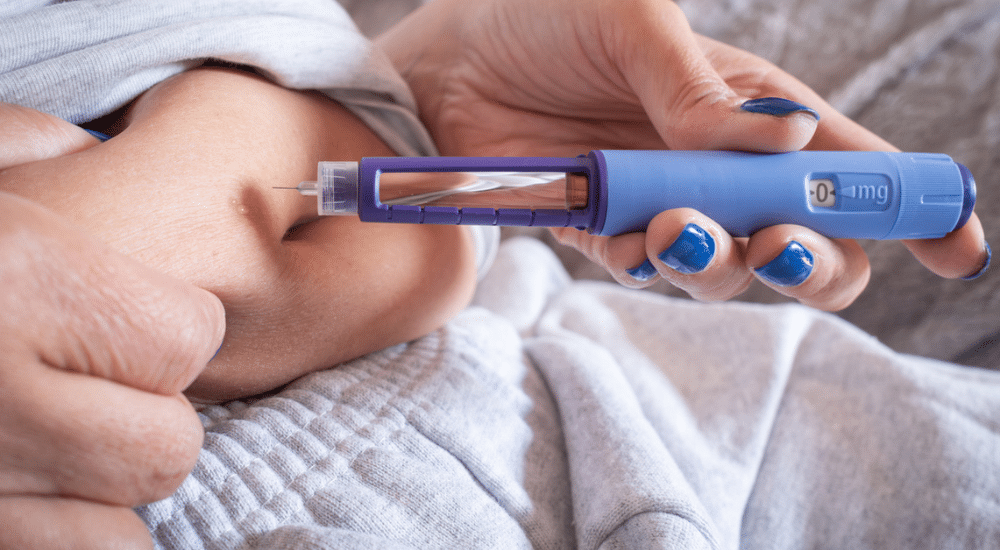 Femme mature en surpoids injectant une seringue de GLP1 dans son ventre.